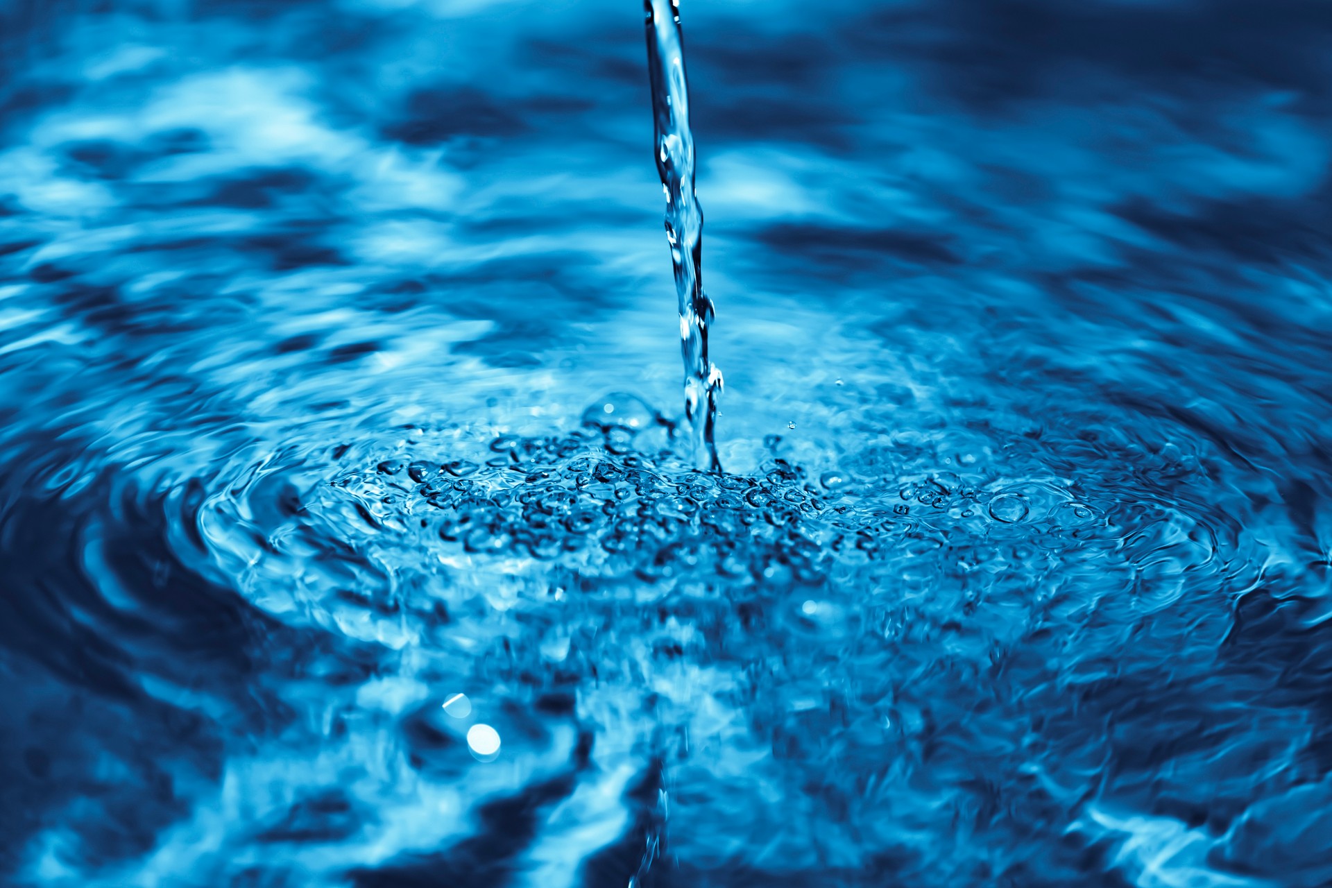 Close up of water falling on transparent water surface